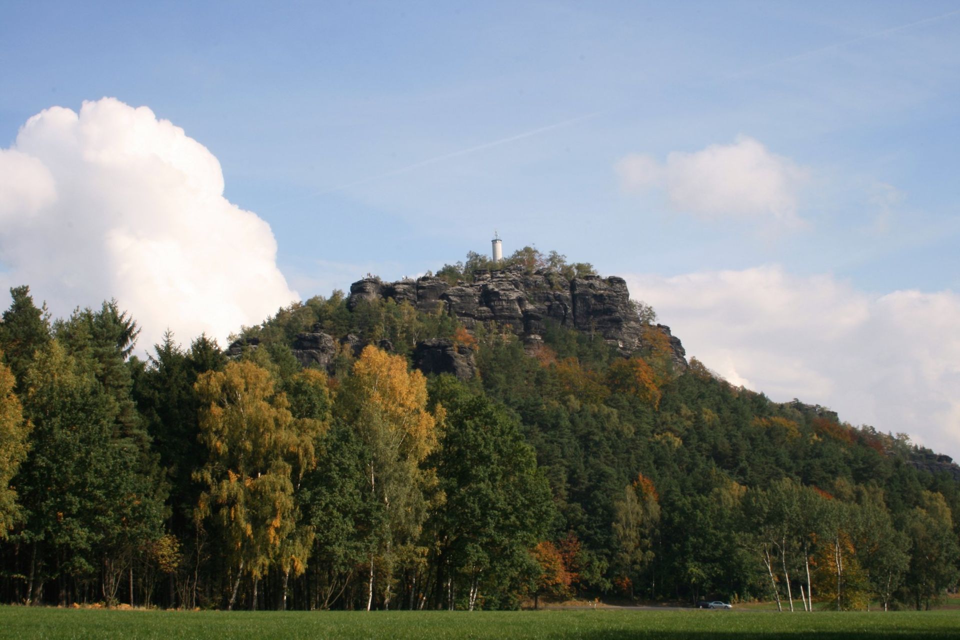 Der Papststein als bewaldeter Tafelberg über Wiesen und herbstlichen Birken
