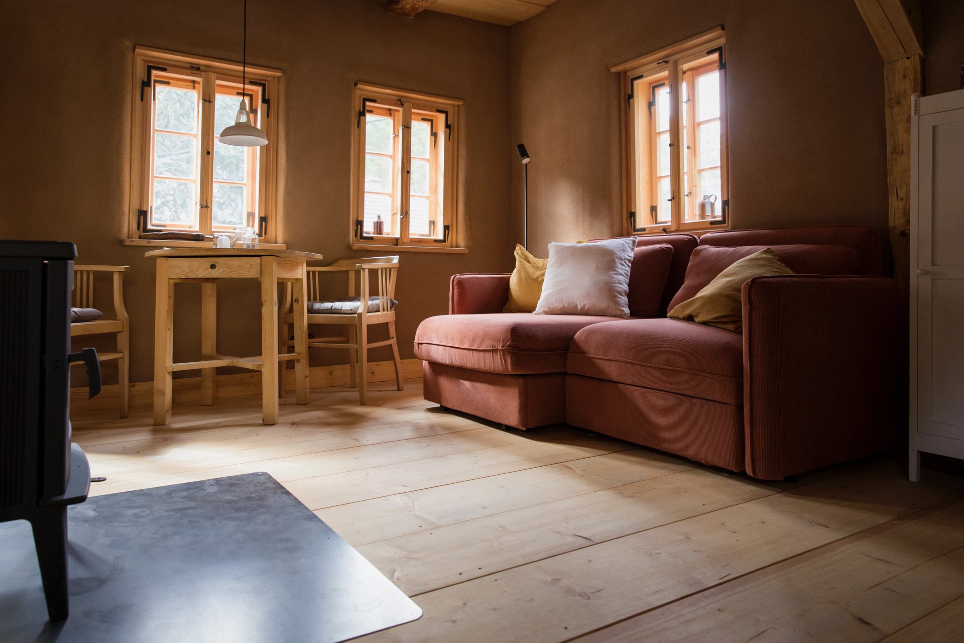 Wohnraum der Steinbrecherstube mit Sofa und Blick ins Tal